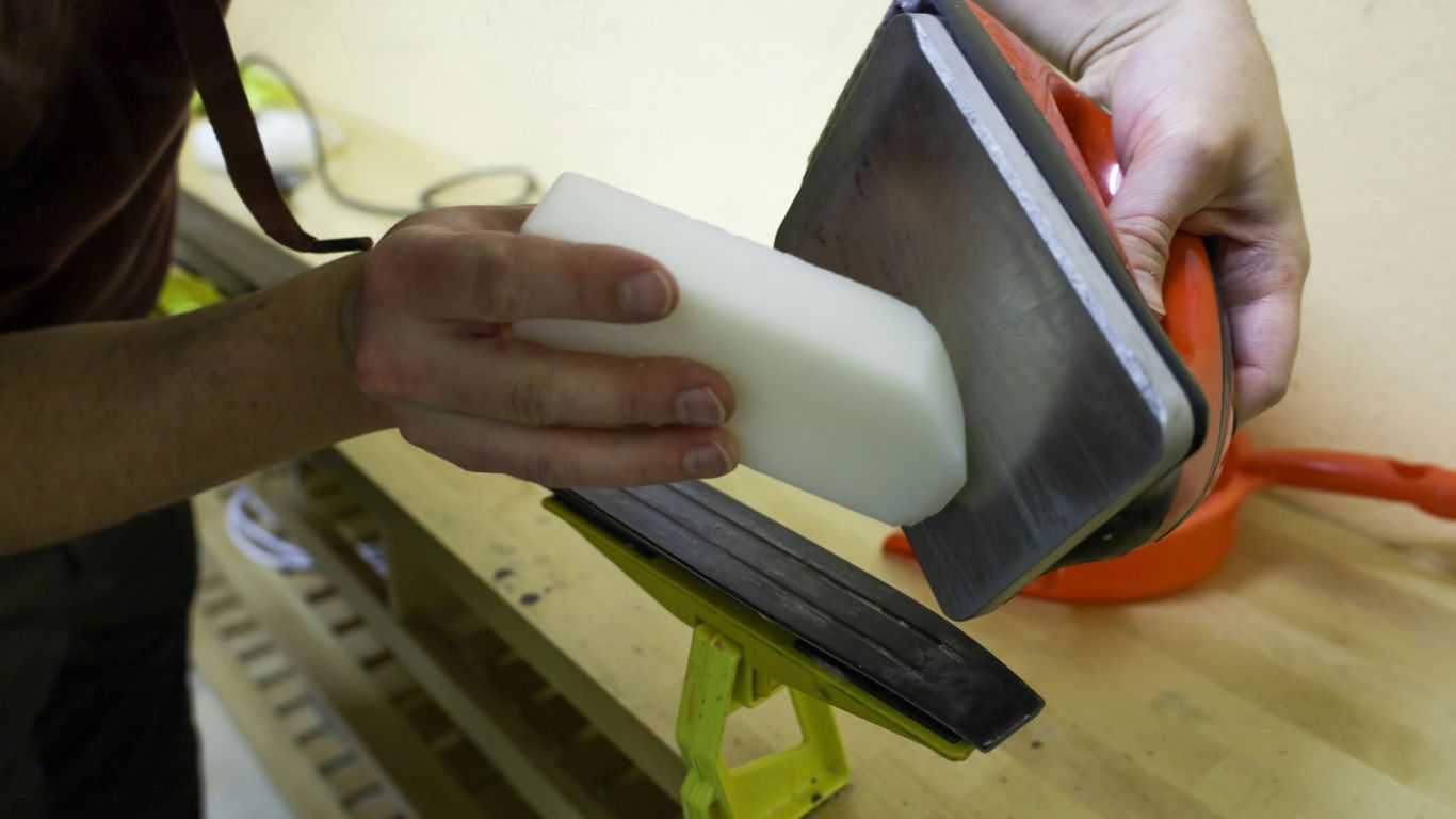 Artisan polishing the edge of a clear acrylic piece