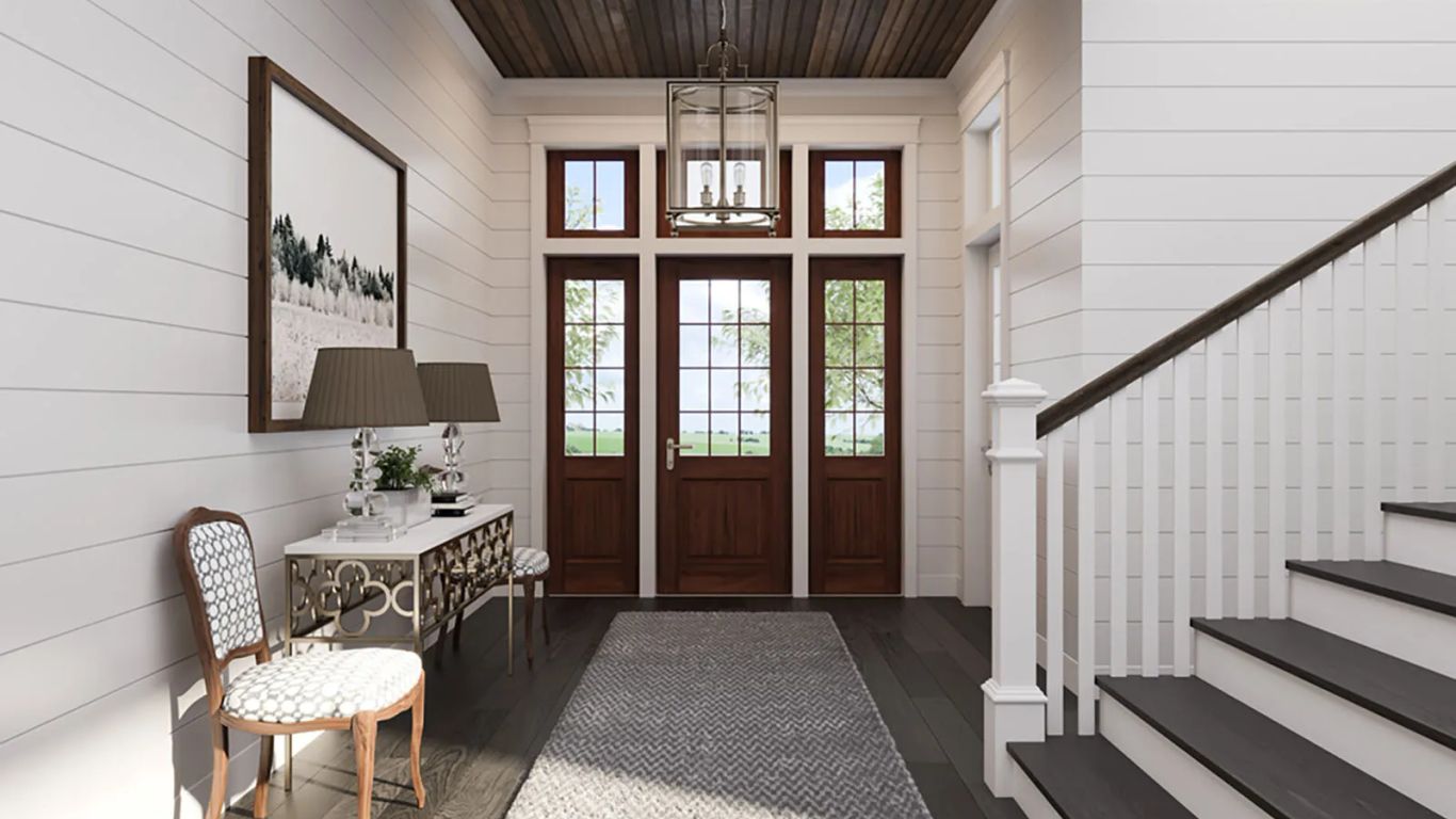 A bright entryway with a staircase, console table, and three doors.