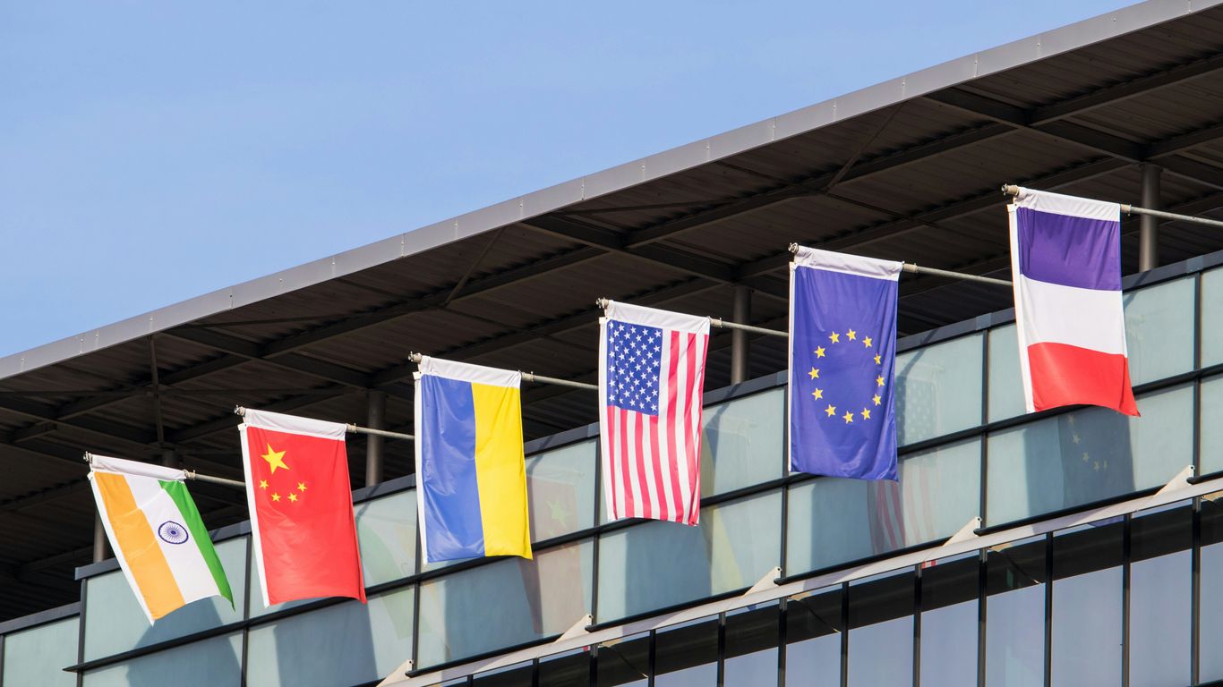 Flags of various nations fly on building.