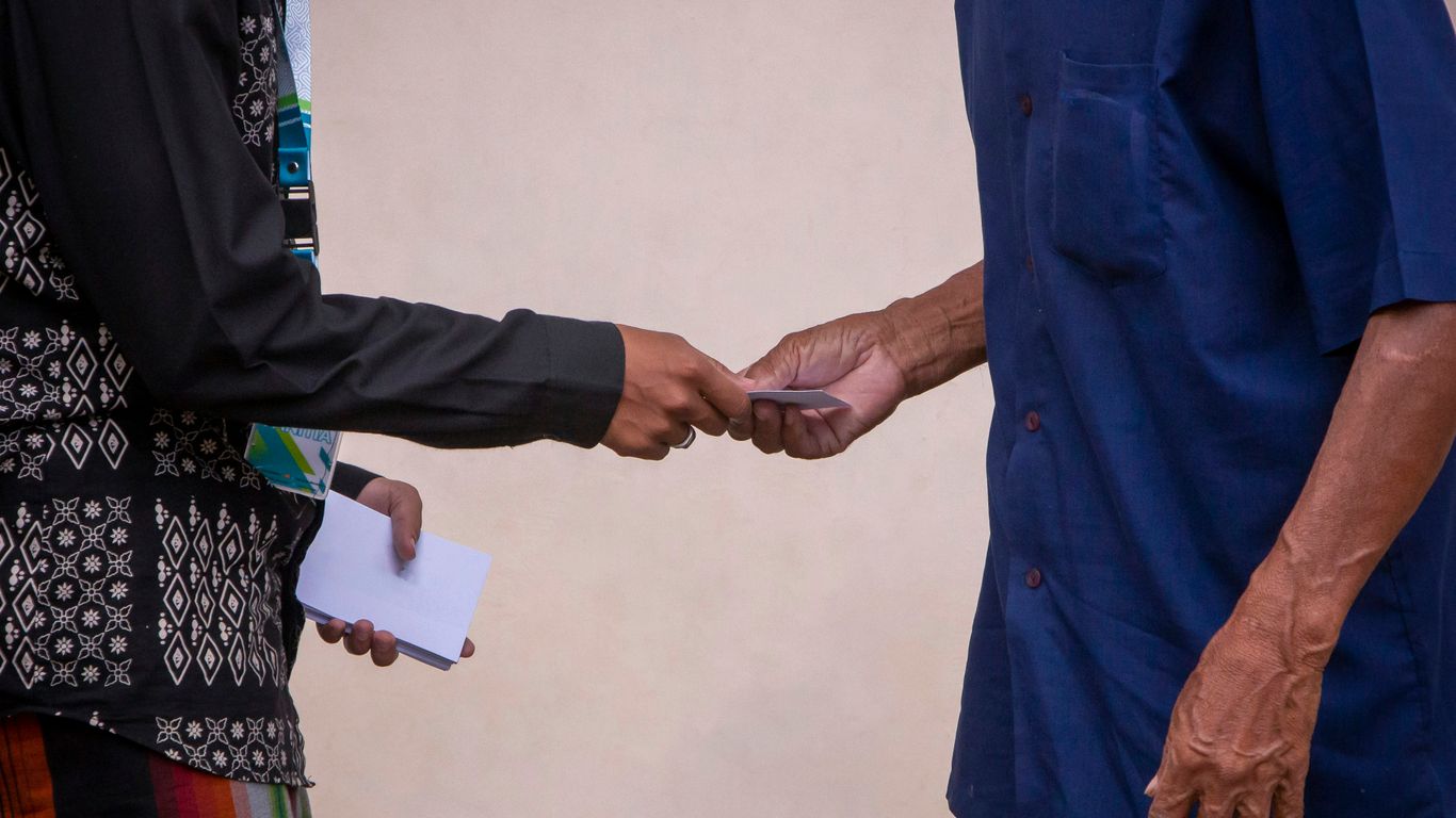 a man handing another man a piece of paper