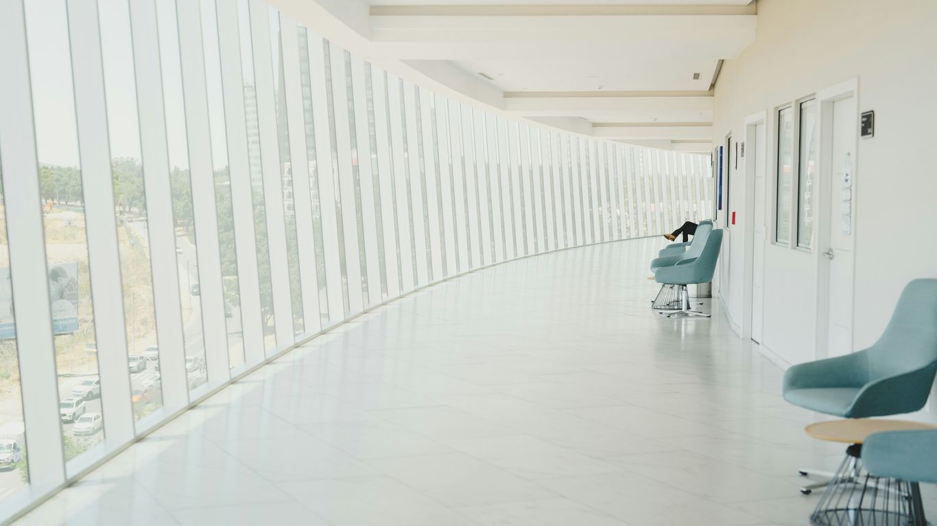 A long hallway with a row of chairs next to a wall