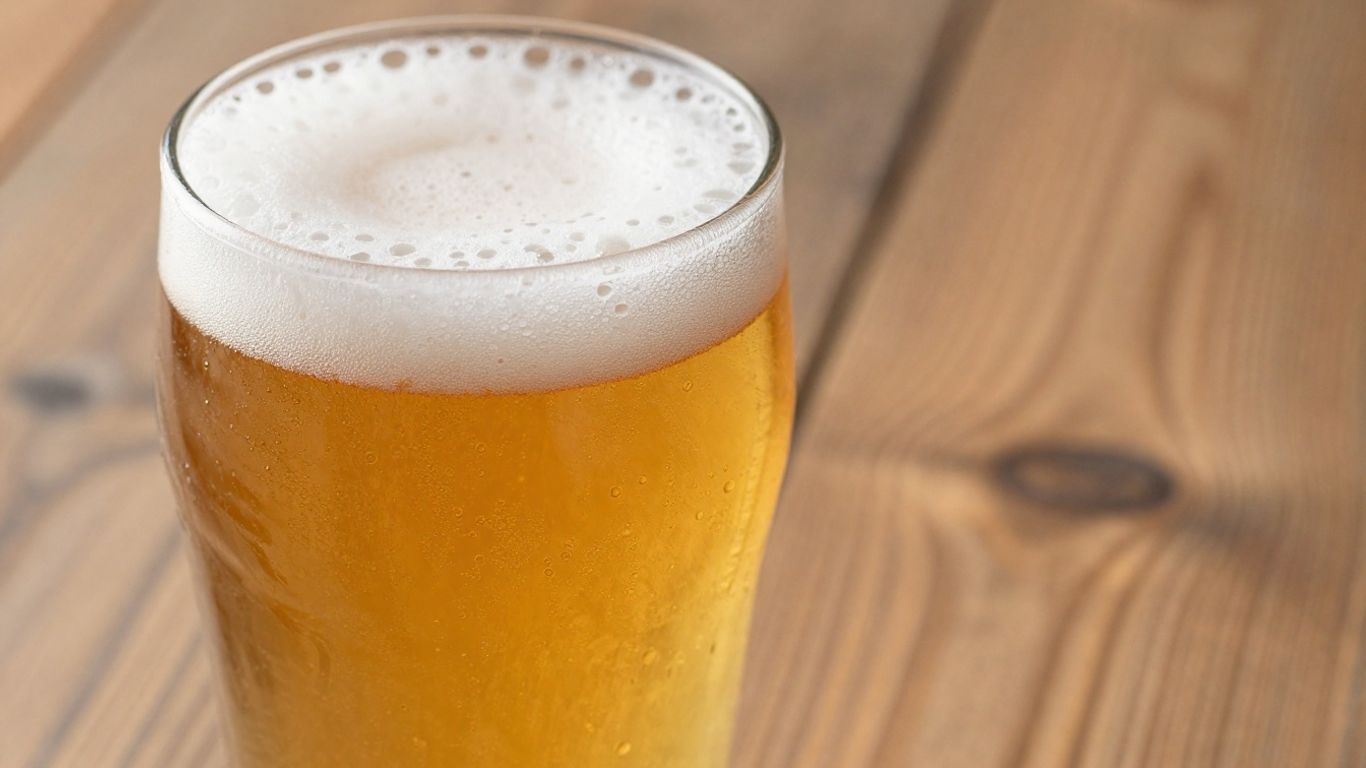 Golden French Saison beer in a glass with condensation.