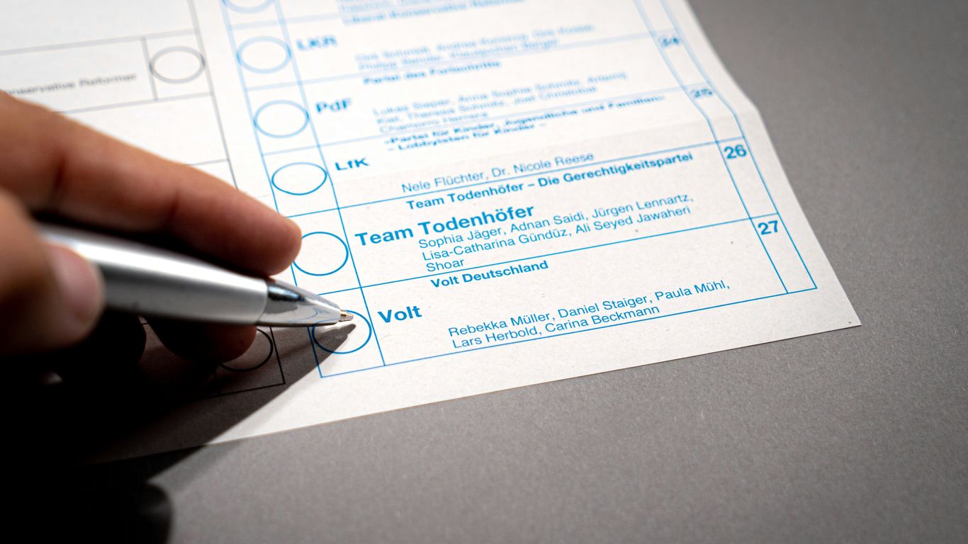 a person holding a pen over a piece of paper