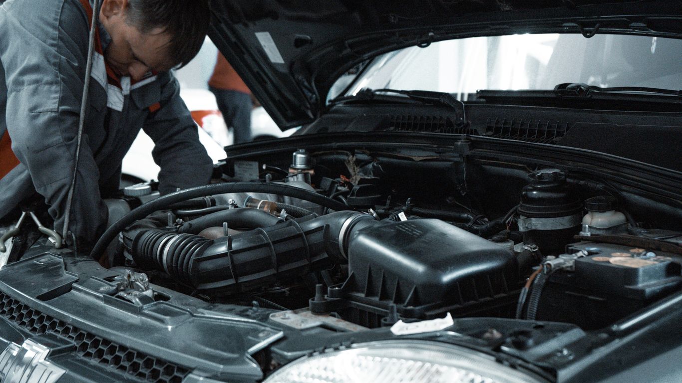 Mobile technician working beside a parked car