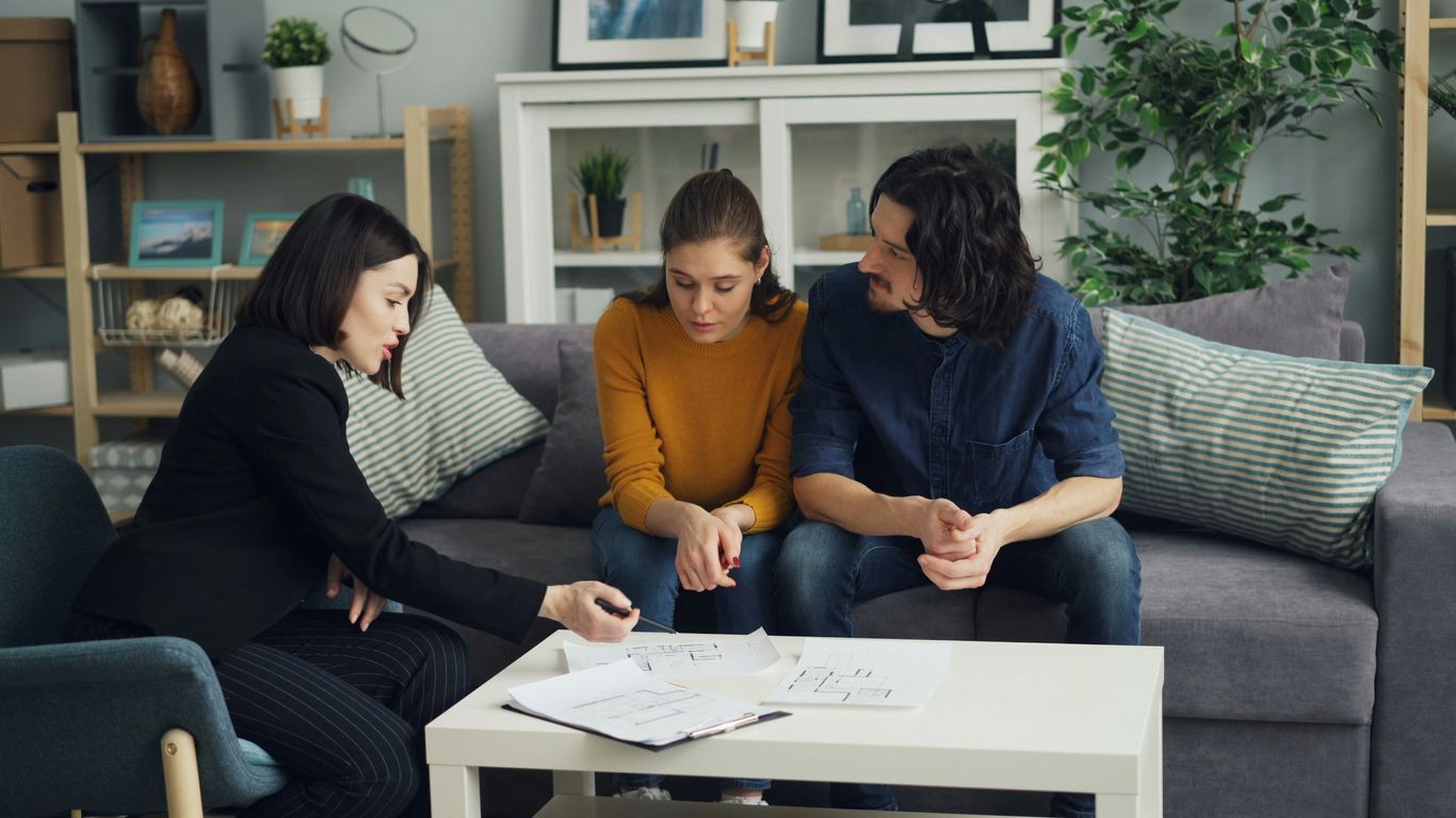 three women sitting on a couch talking to each other