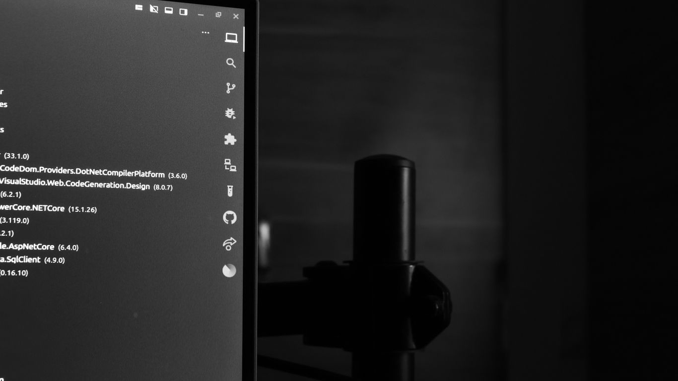 Computer monitor displaying code in a dark room.