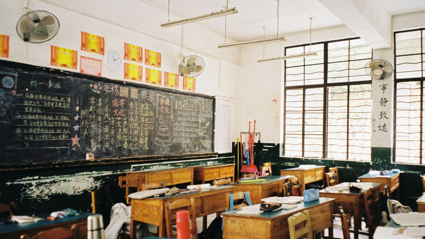 a classroom filled with desks and a chalkboard