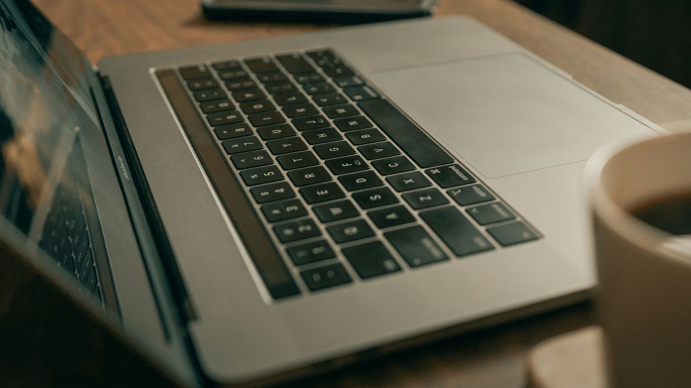 macbook pro on brown wooden table