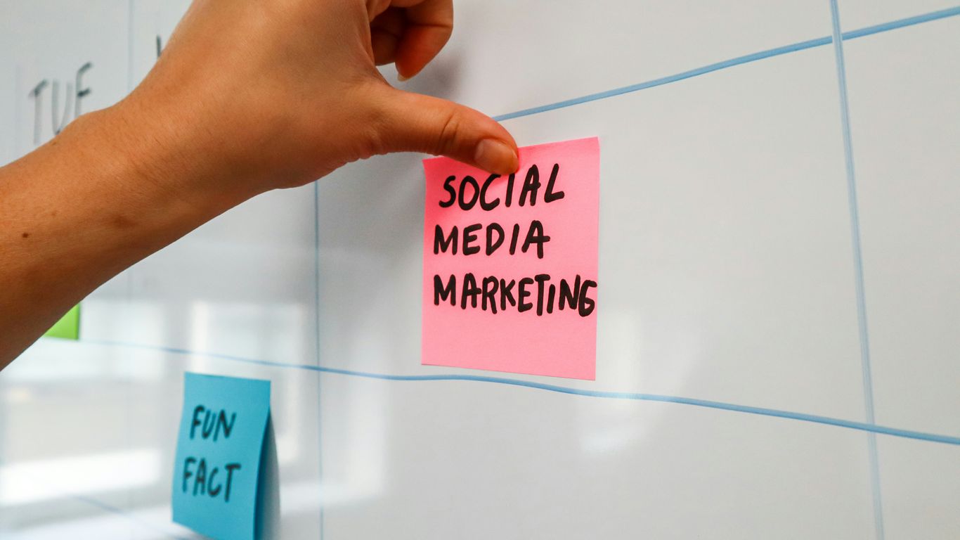 a hand is writing on a sticky note