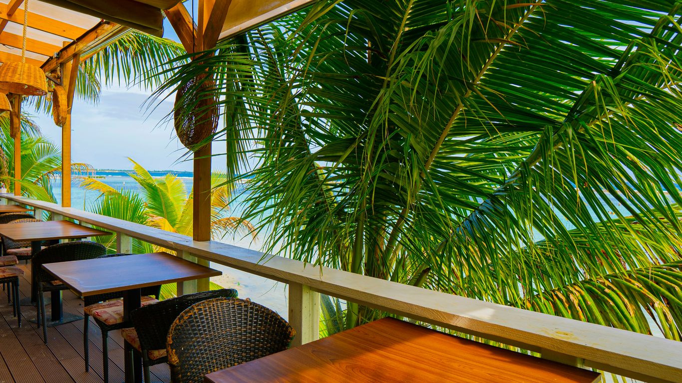 White colonial hotel veranda beneath palms