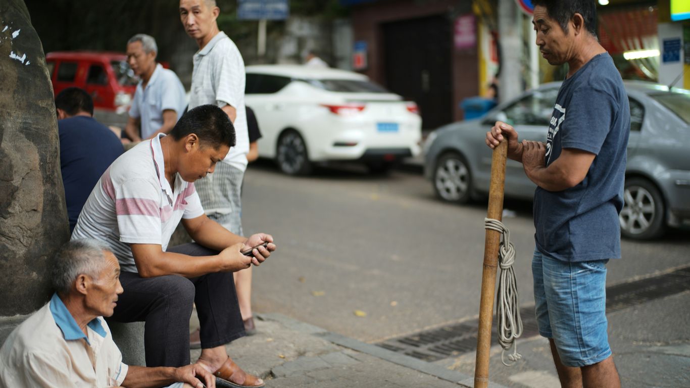 Men gathered on a street corner in a city.
