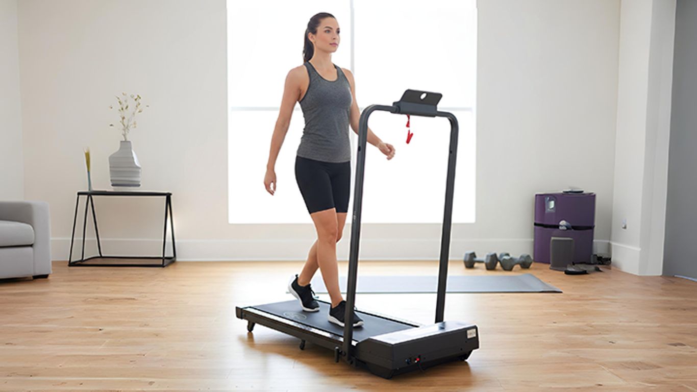A person walks on a treadmill in a bright, modern room.
