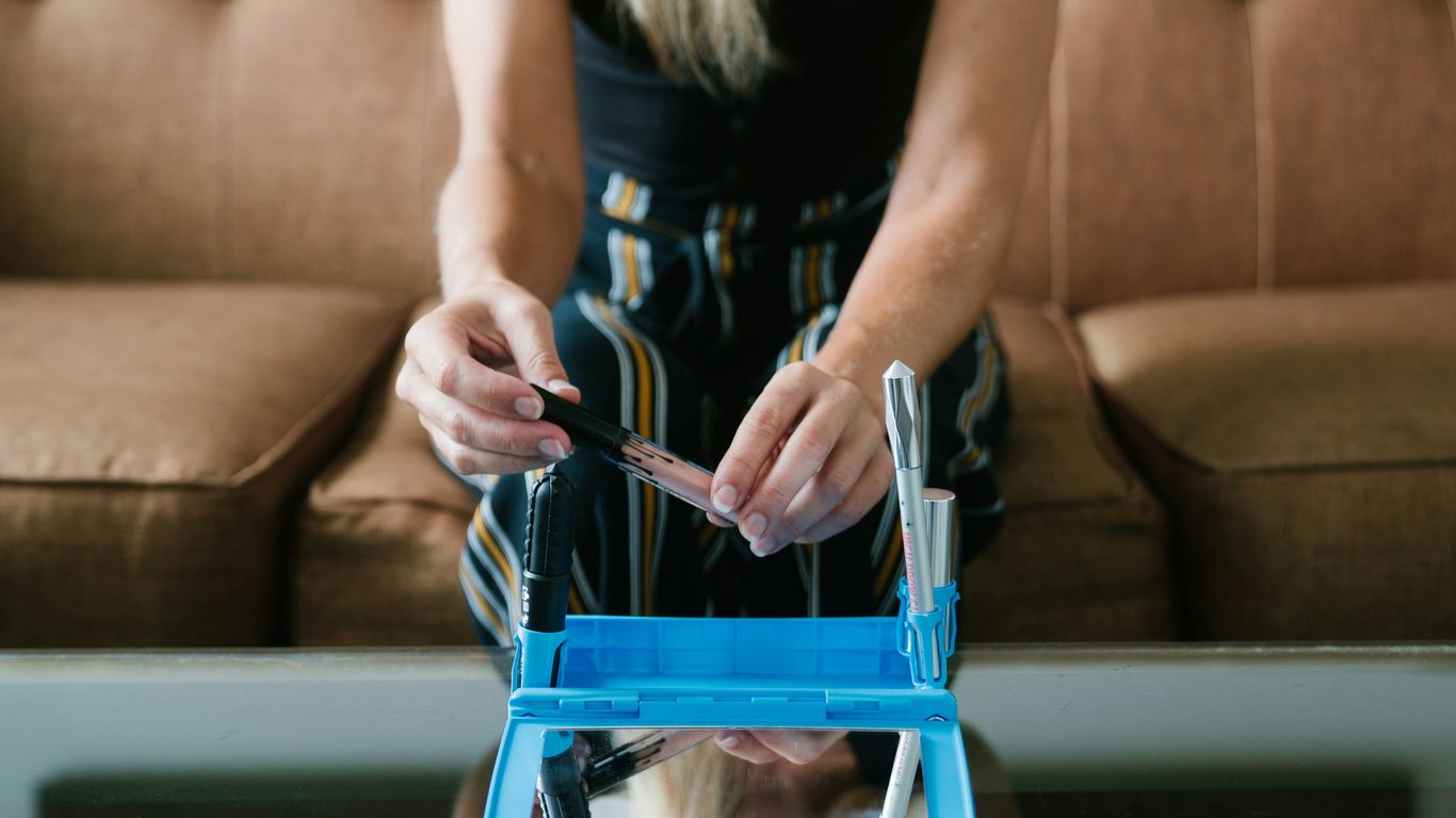 woman in black tank top holding blue and white plastic crate