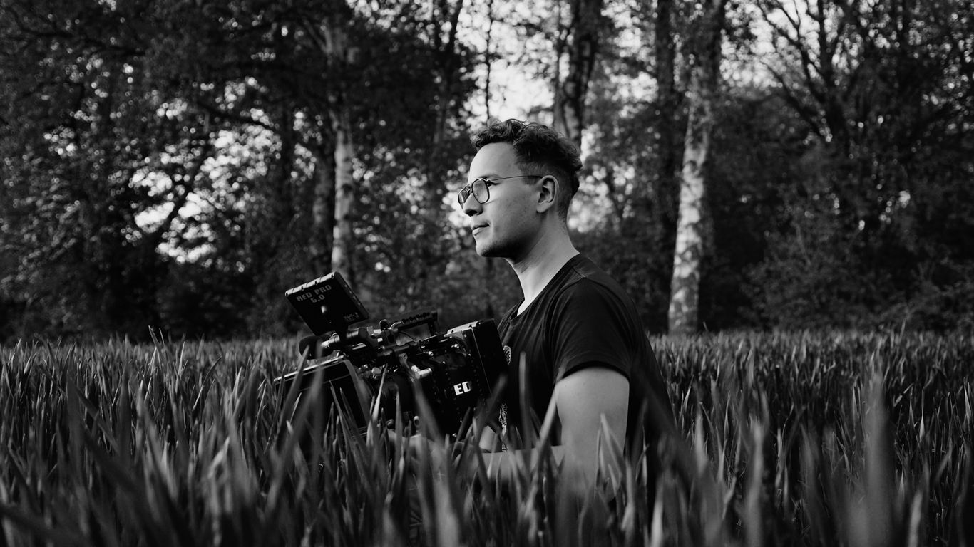 Filmmaker operating a compact camera outdoors