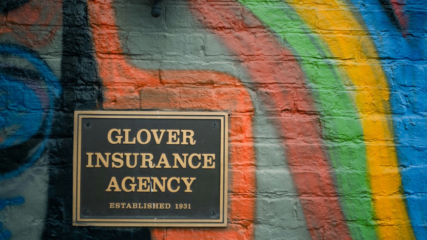 a sign on a brick wall that says glover insurance agency