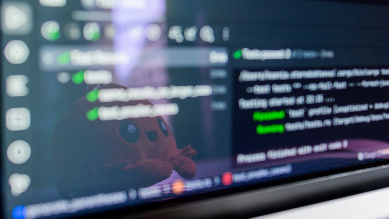 Computer screen displaying code with a toy reflected.