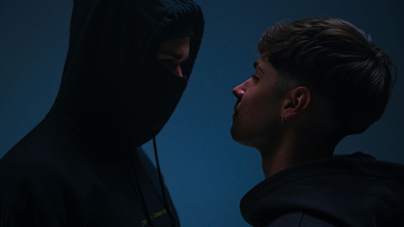 A man in a hoodie standing next to a man in a black hoodie
