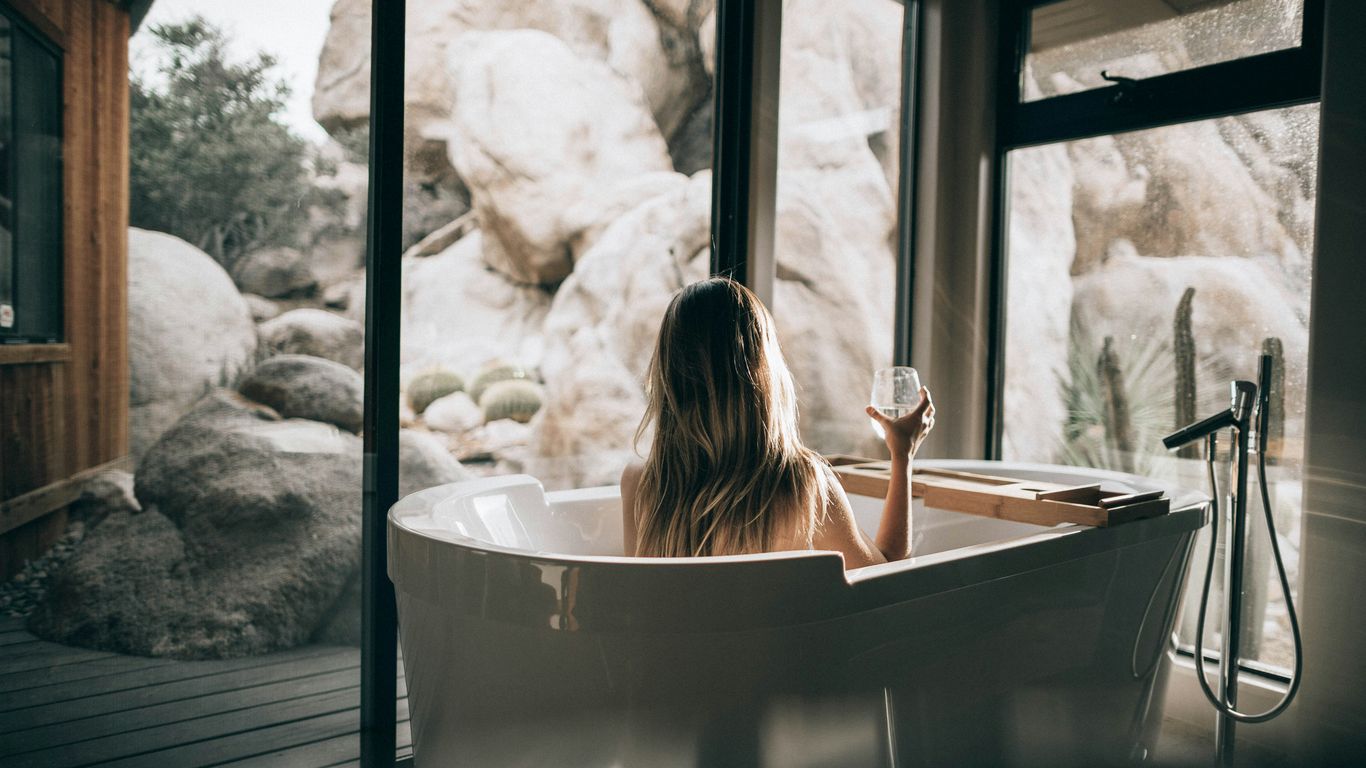 Freestanding marble tub beside window
