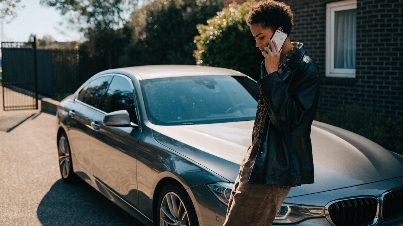 BMW owner checking vehicle details beside car