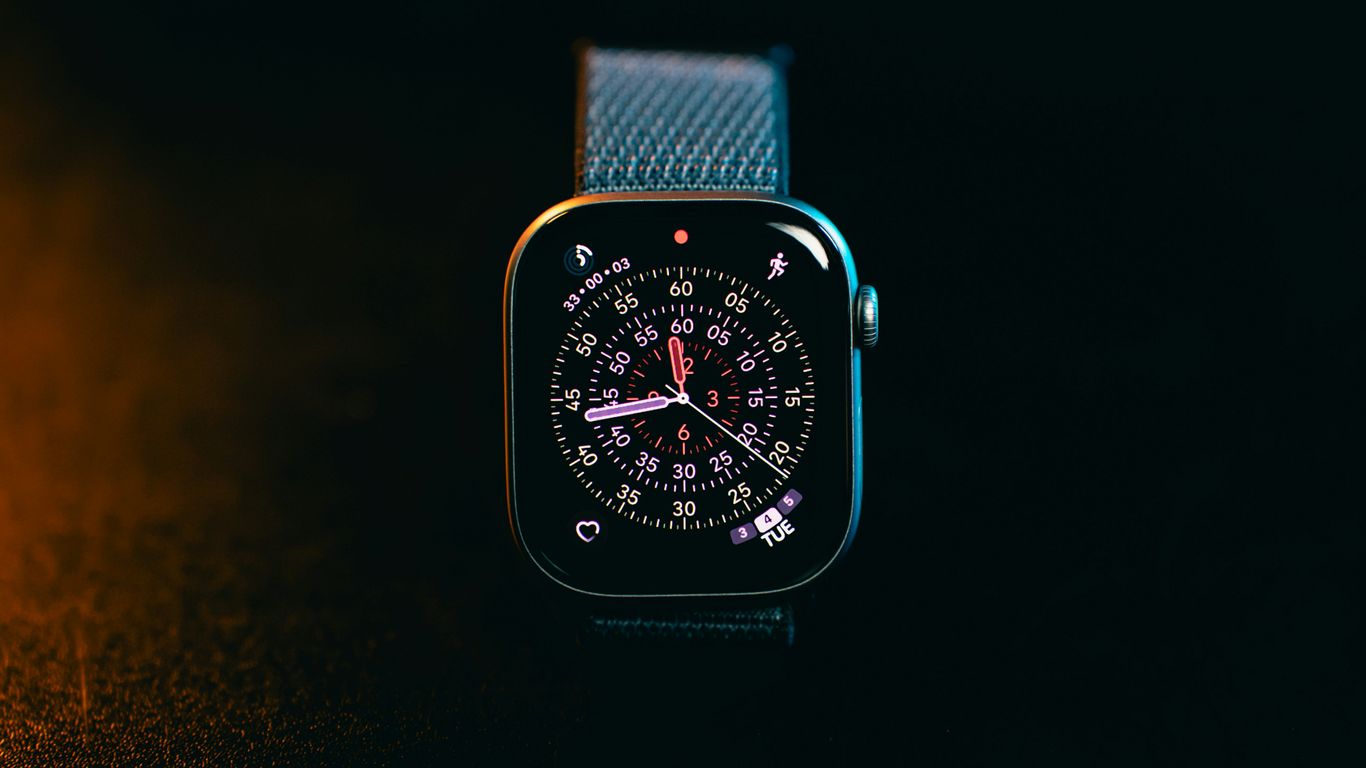A smartwatch with a colorful face on a dark background
