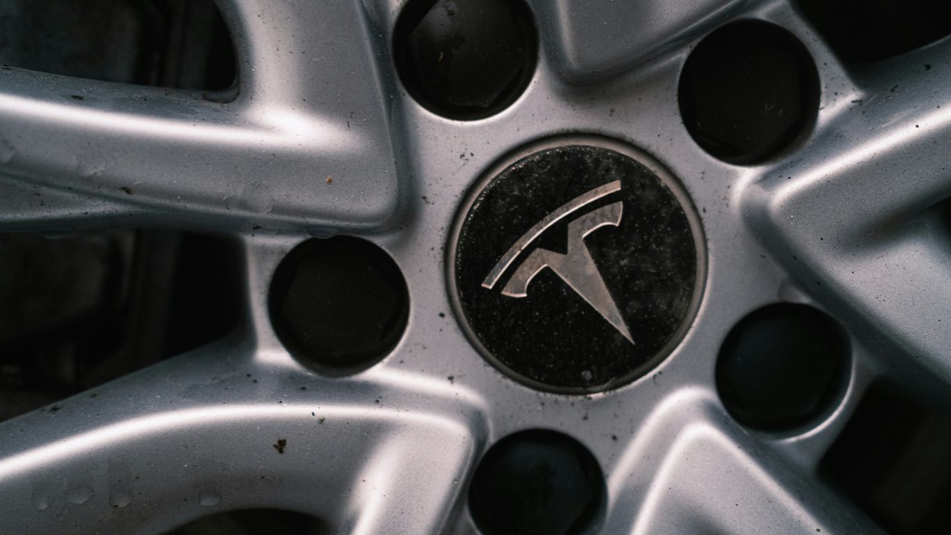 Close-up of a tesla car wheel with logo.