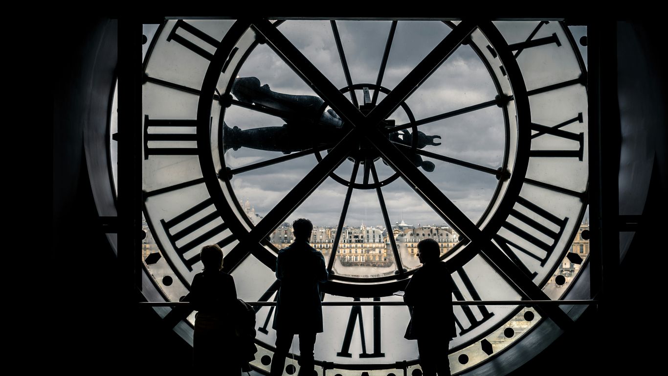 man and woman standing in front of black and white round analog wall clock
