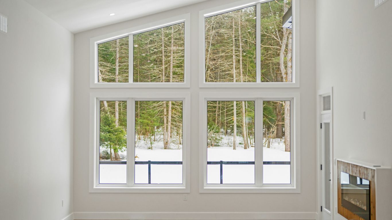 Modern living room with large windows overlooking snowy forest