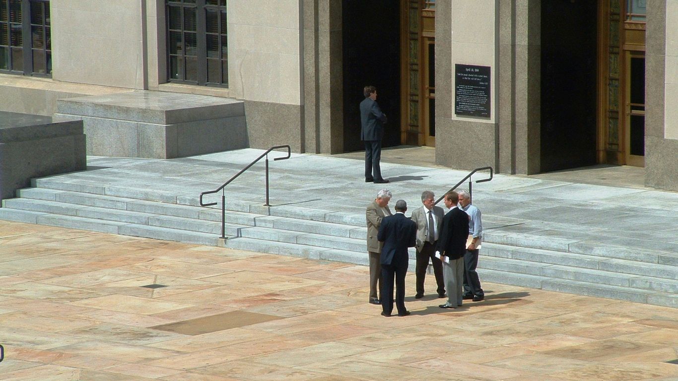 a group of men standing in front of a building