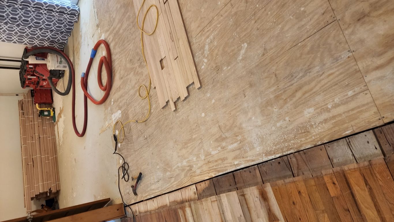 Construction area with wood flooring and renovation tools present.