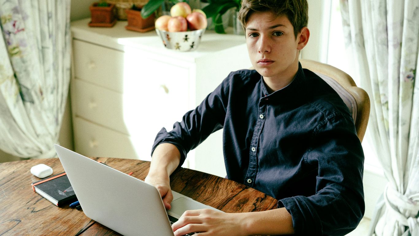 a man sitting at a table using a laptop computer