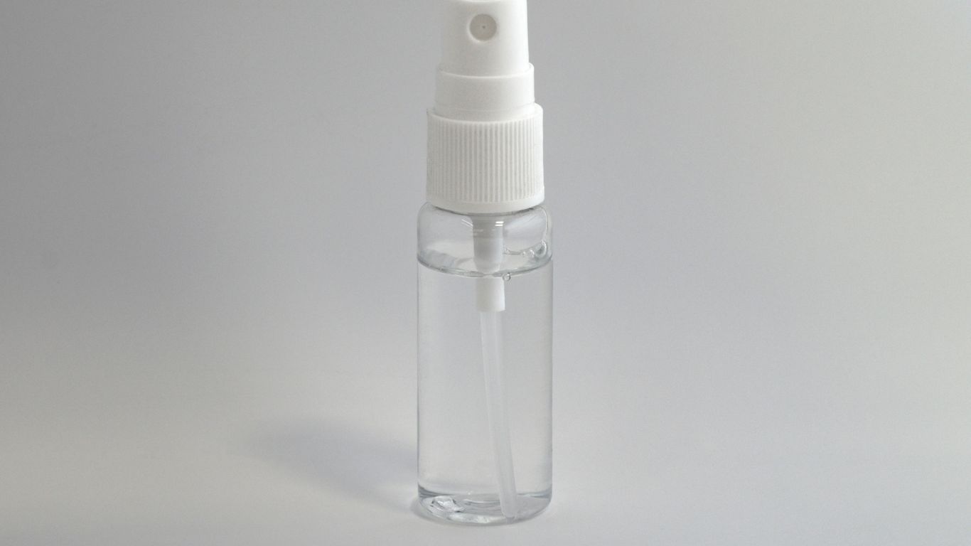 A yoga mat and spray bottle beside towel