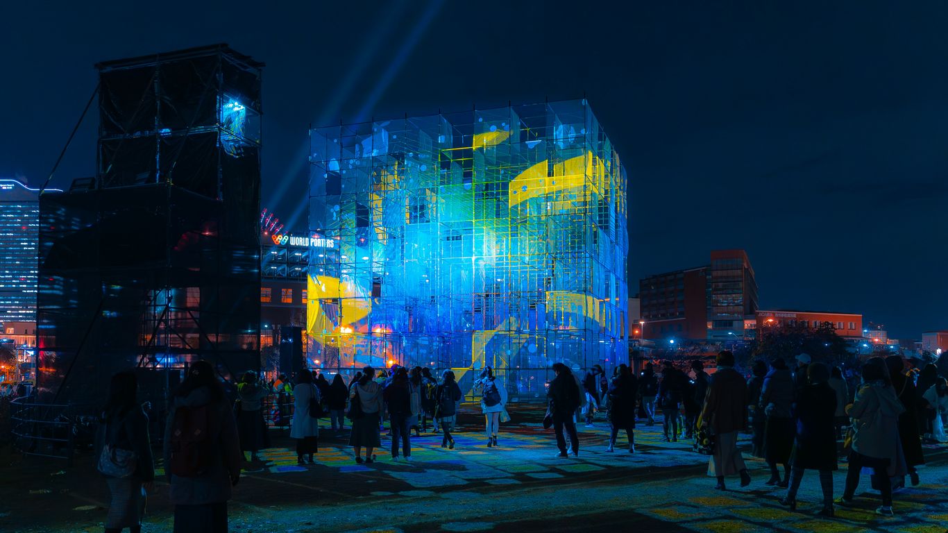 a group of people standing around a building at night