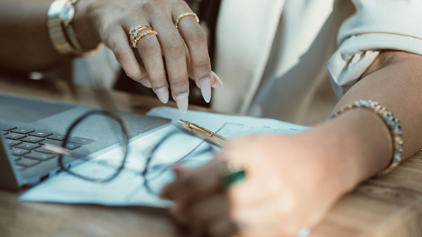A woman sitting at a table working on a laptop computer