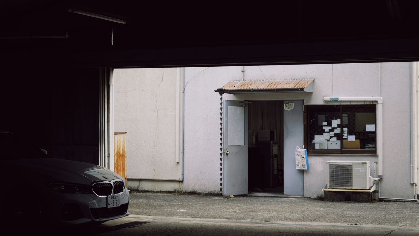 Car parked outside a warehouse entrance