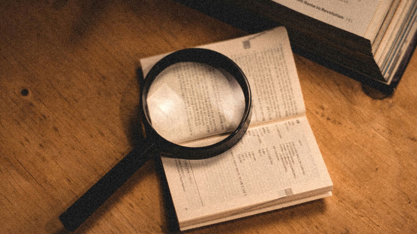 a magnifying glass sitting on top of an open book