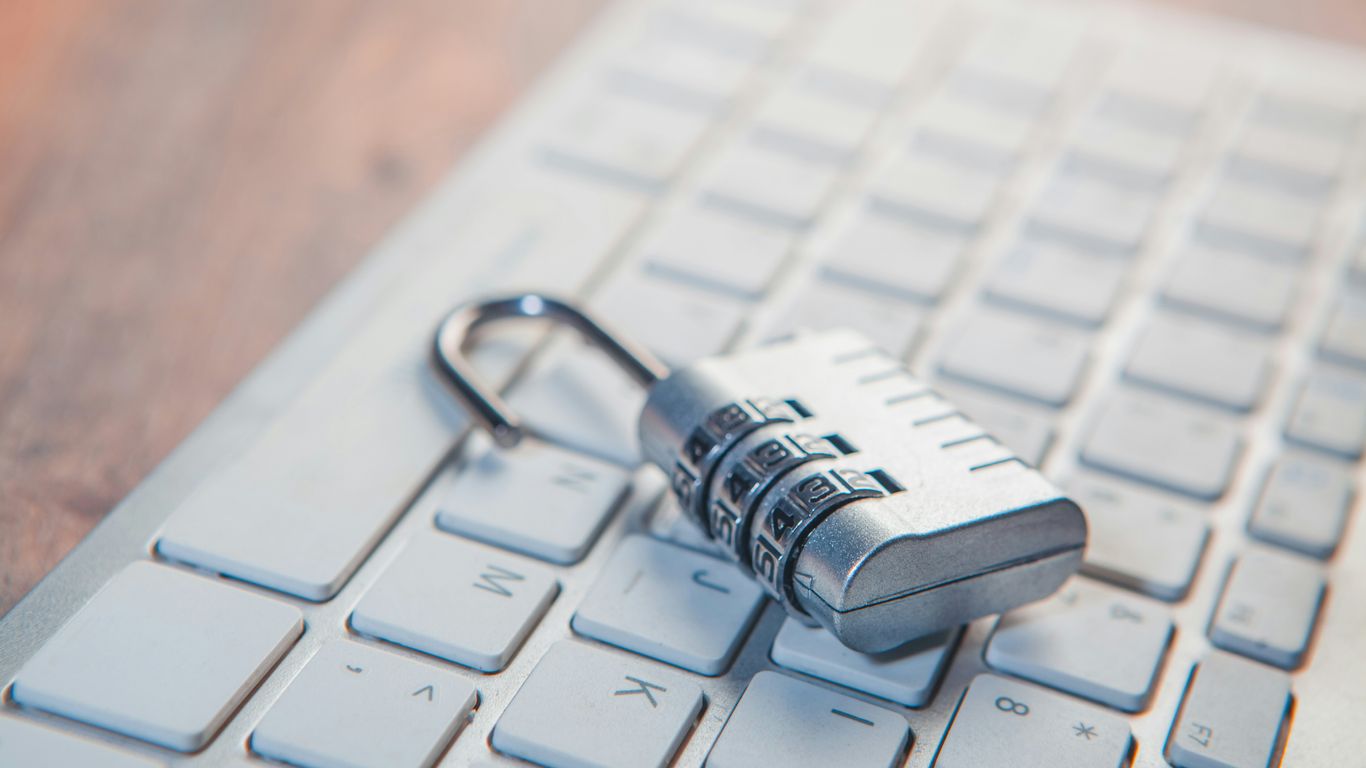 A combination lock rests on a computer keyboard.
