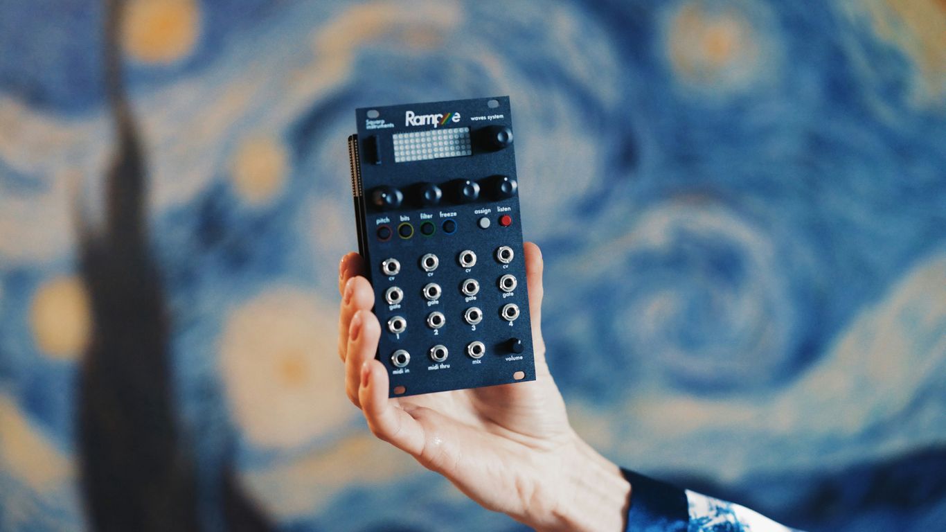 Hand holding a small electronic music device.