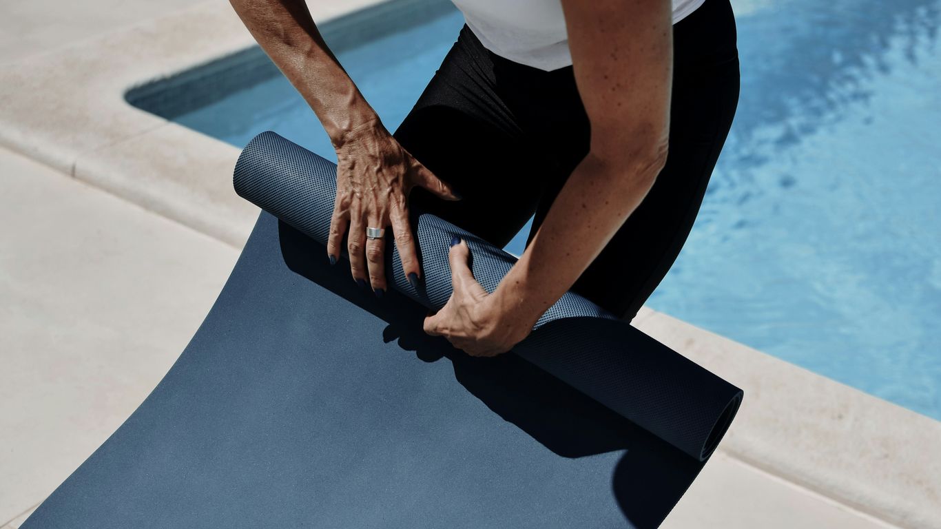 Rolled yoga mat with adjustable carrier strap