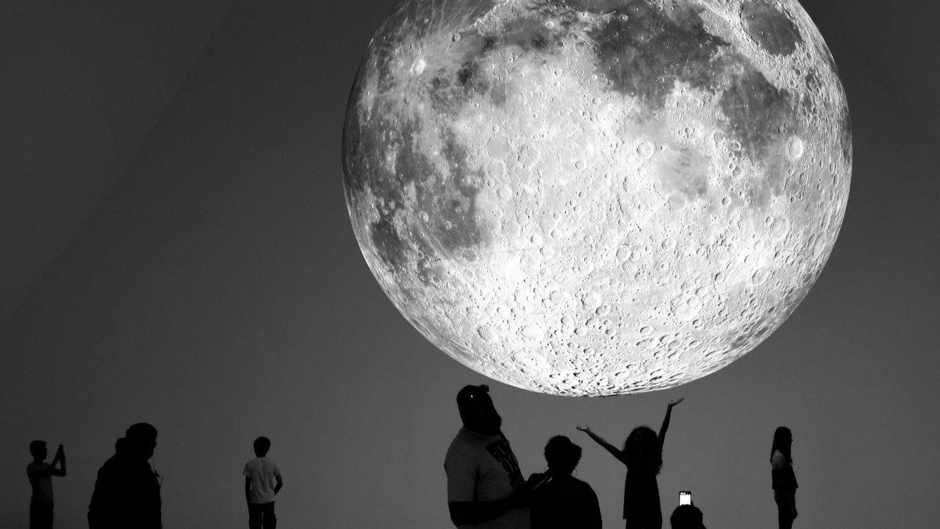 Giant moon installation with people observing