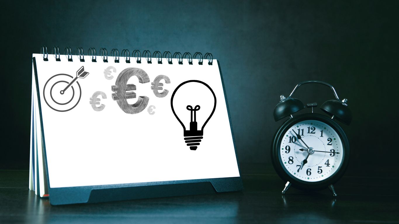 Desk calendar with business symbols and alarm clock.