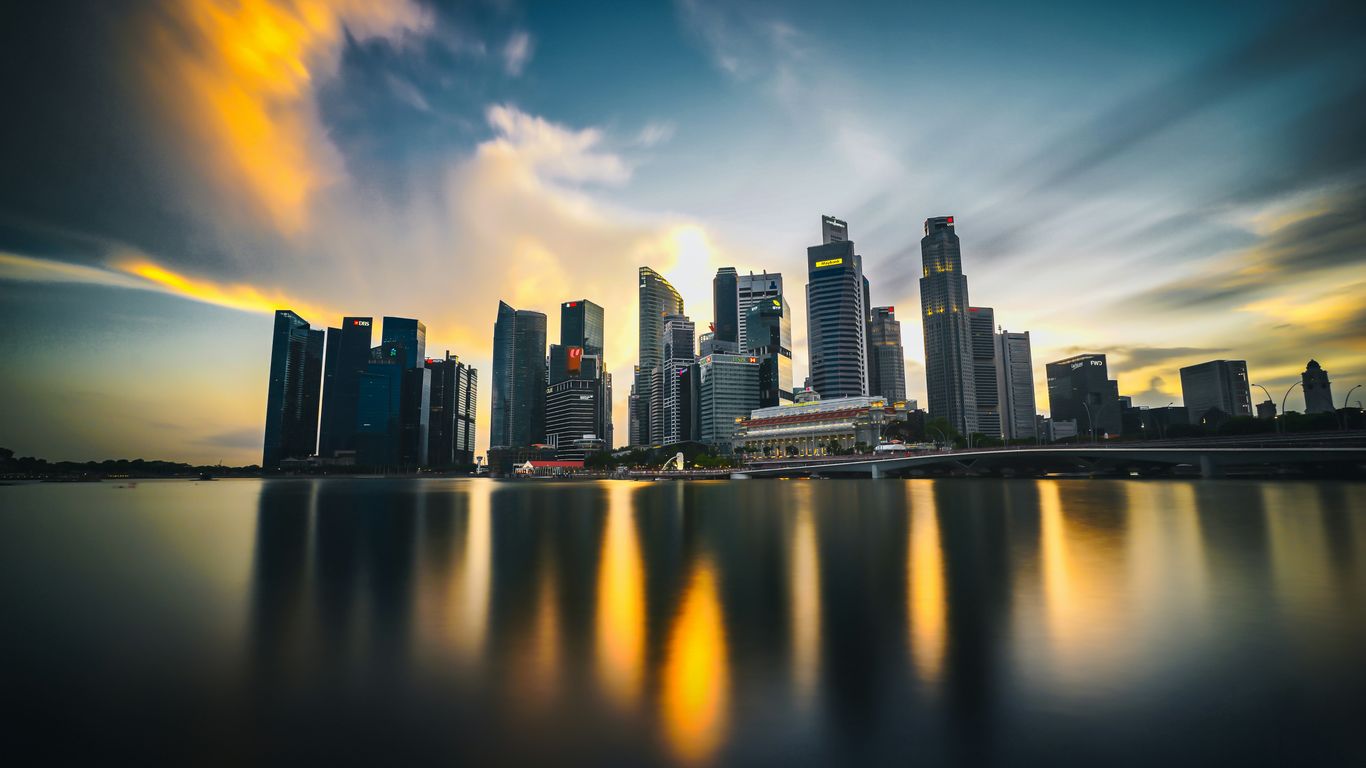 city skyline across body of water during sunset