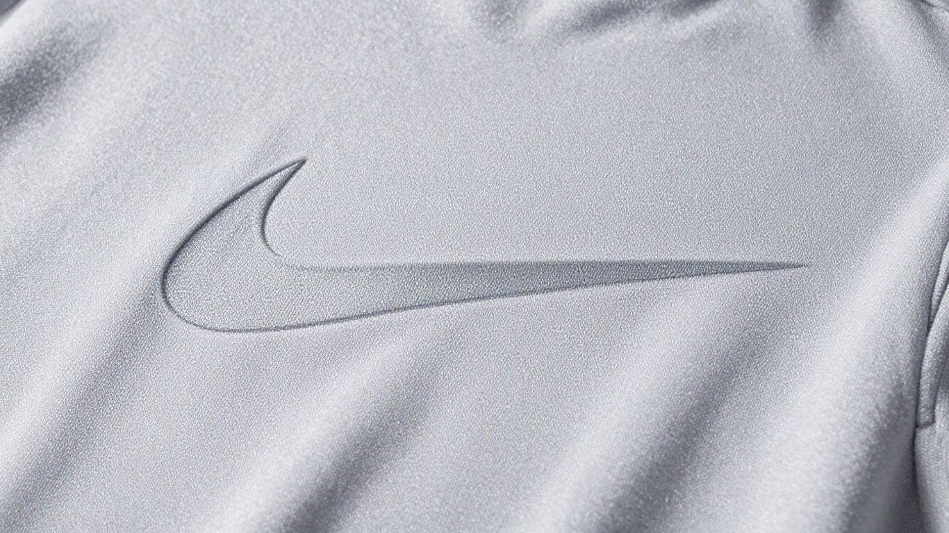Textura Nike Tech Fleece detaliată și lumina ambientală.