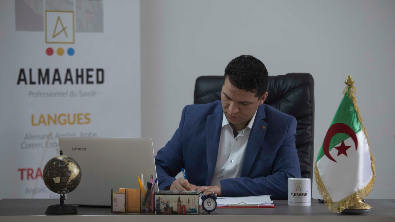 man in blue suit jacket sitting on black office rolling chair
