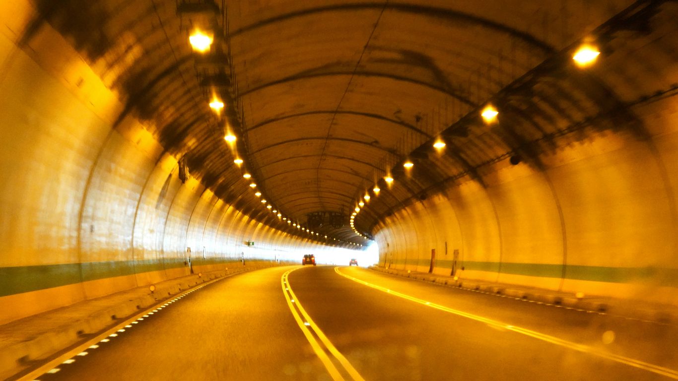 a car driving through a tunnel with lights on
