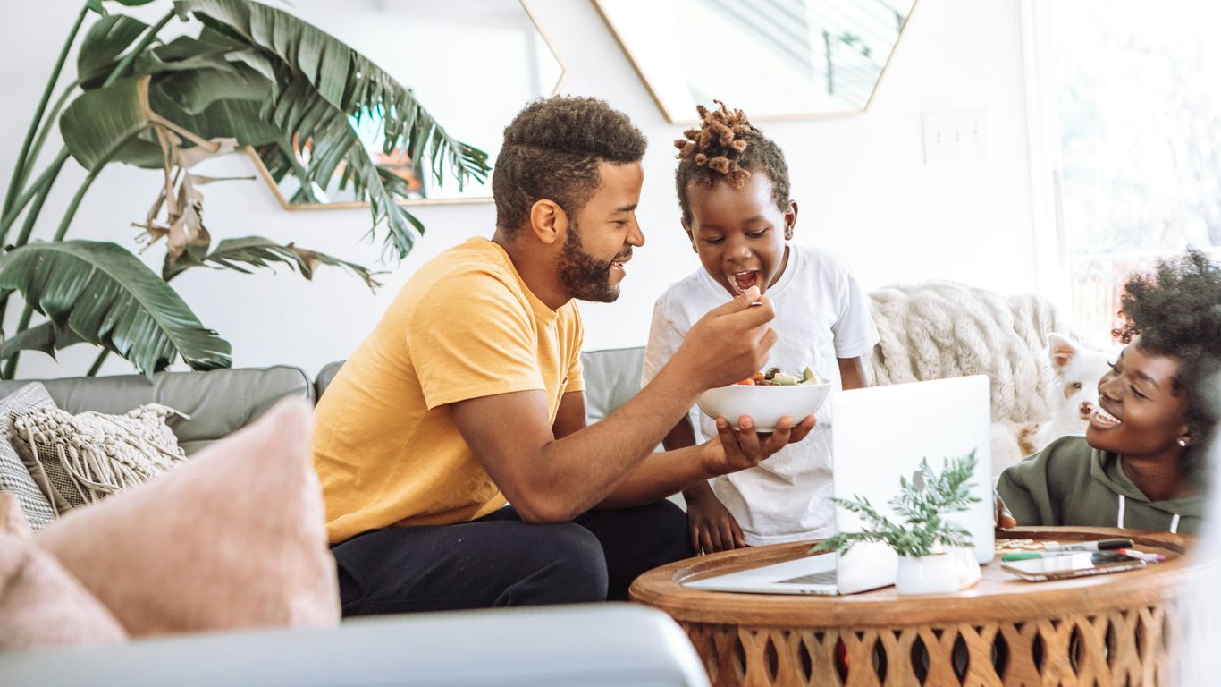 man in yellow crew neck t-shirt sitting on white couch