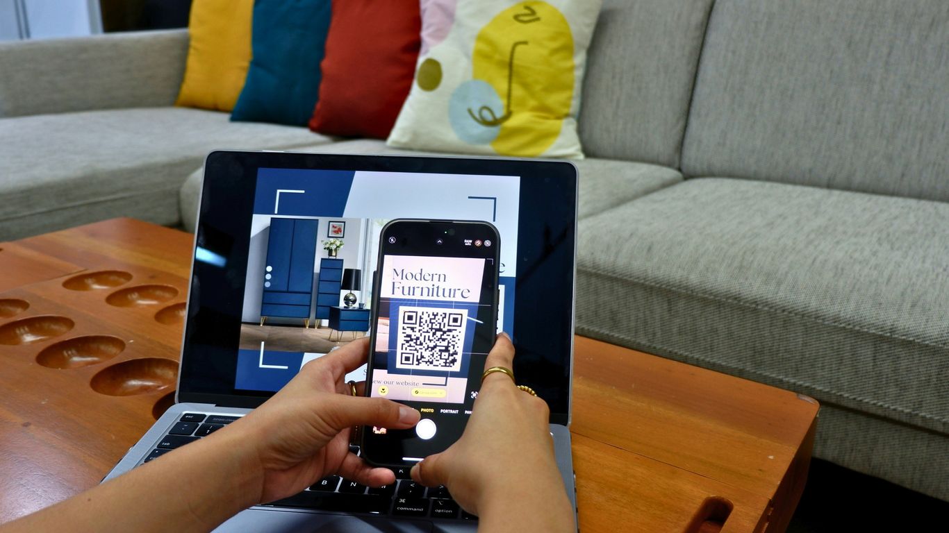 a person using a laptop computer with a qr code on the screen