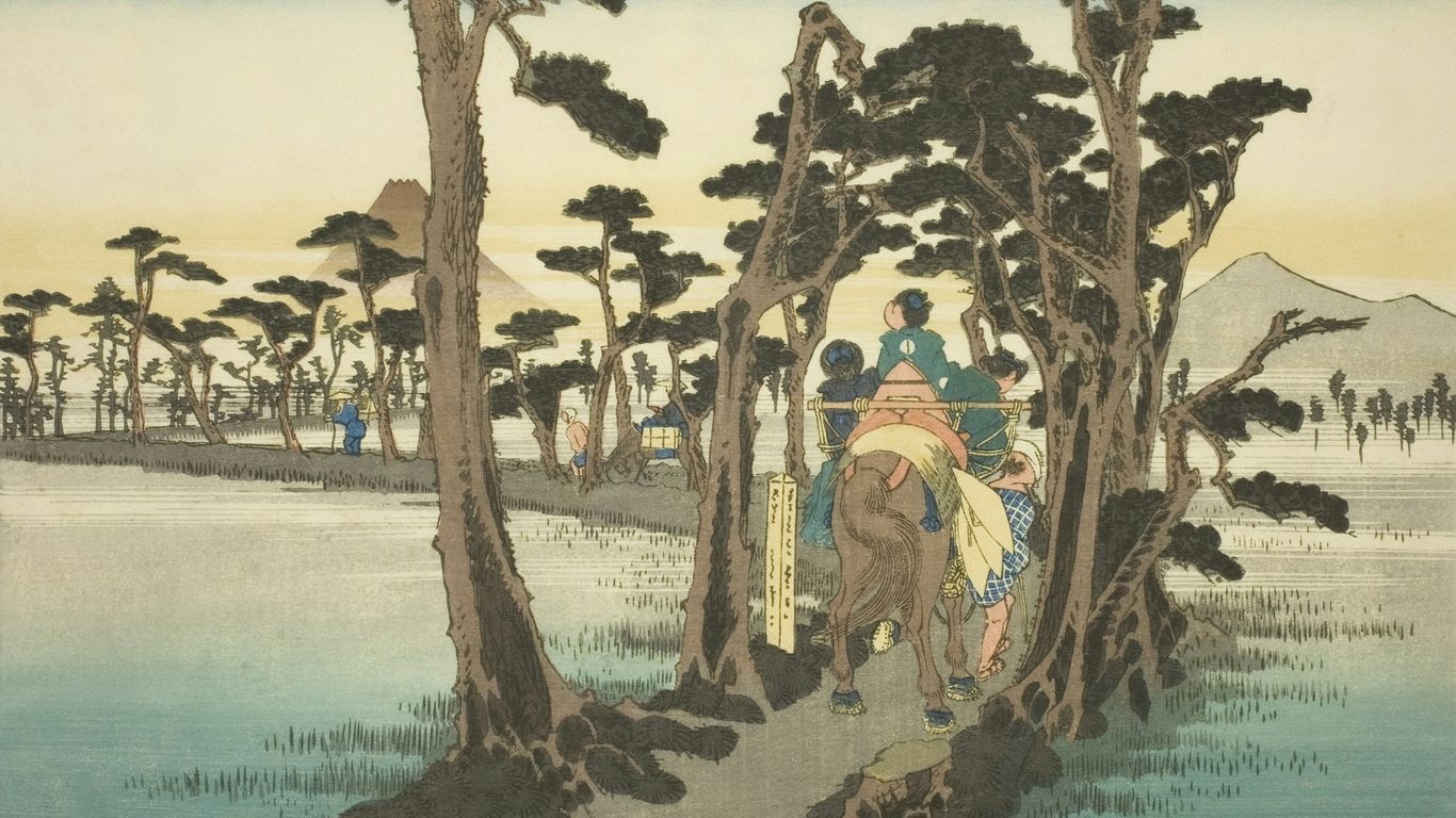 People on horseback cross a bridge lined with trees.