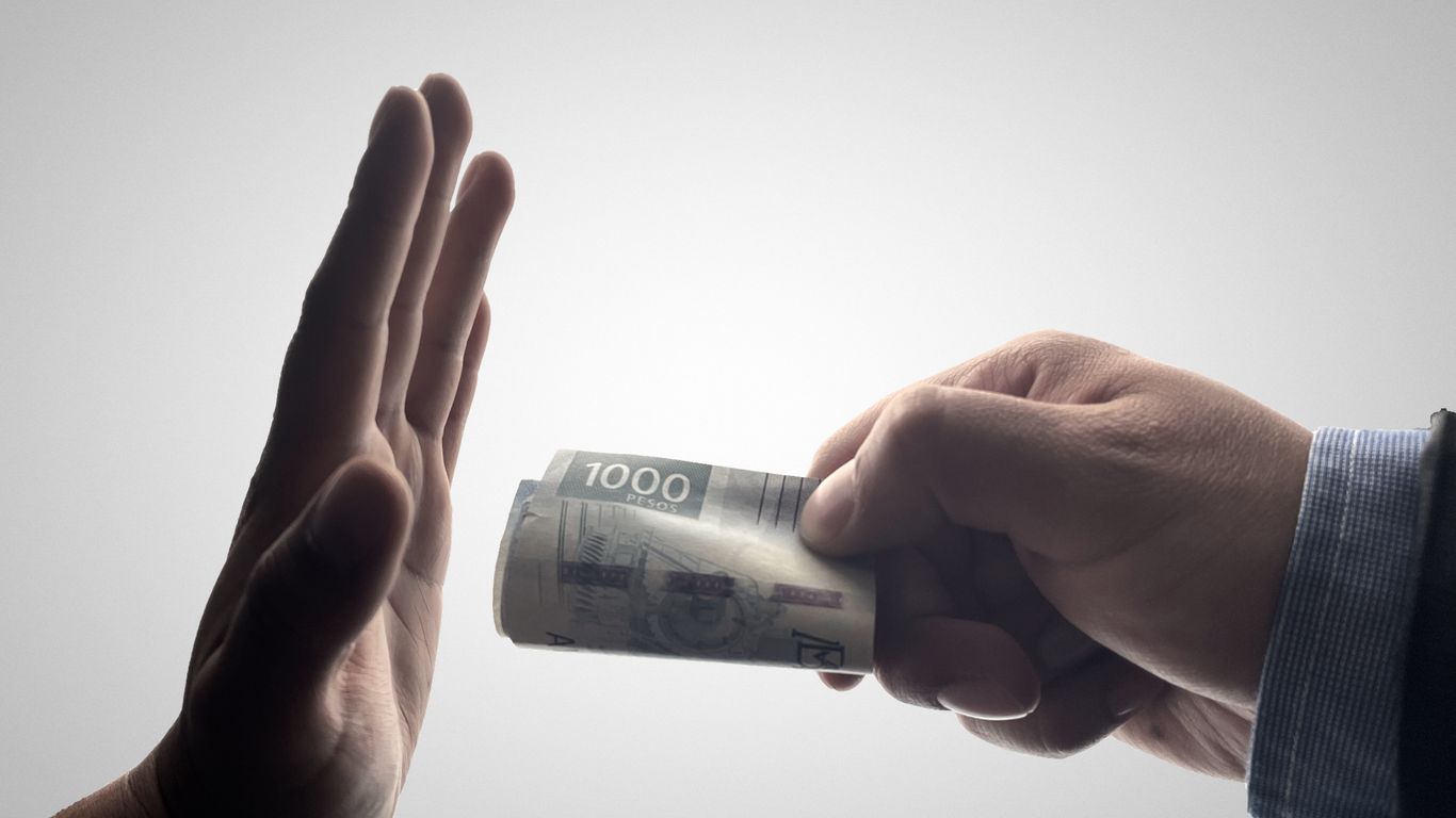 a person holding a stack of cash