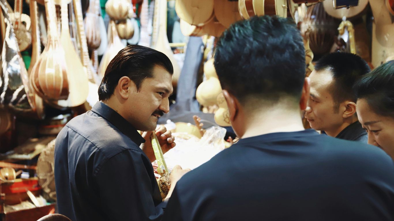 four people standing in front of guitar stall