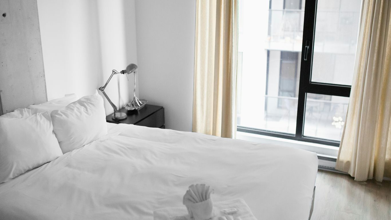 Hotel towels and white bed linens arranged neatly